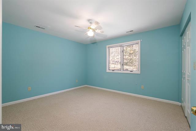 unfurnished bedroom with visible vents, baseboards, a ceiling fan, carpet floors, and a closet