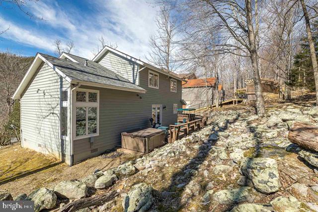 view of side of home featuring crawl space and a wooden deck