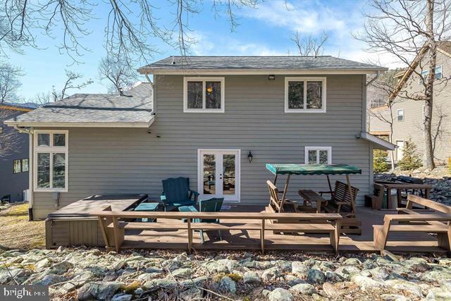 rear view of house featuring french doors and a wooden deck