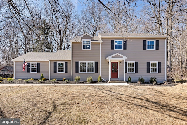 colonial-style house with a front lawn