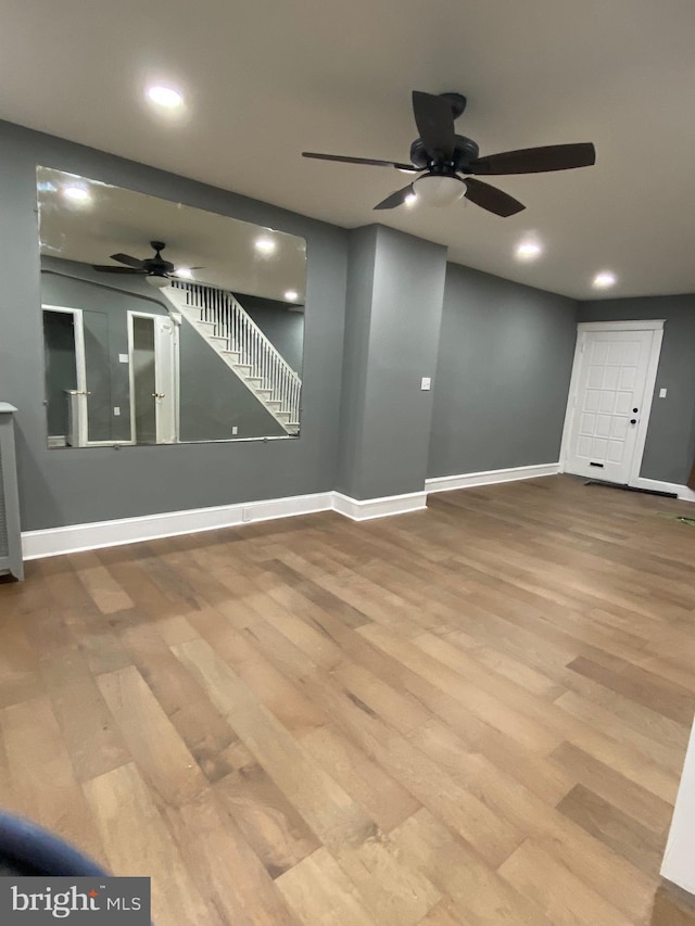 unfurnished living room featuring a ceiling fan, baseboards, wood finished floors, and recessed lighting