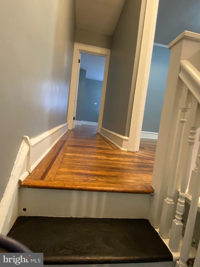 stairs with baseboards and wood finished floors