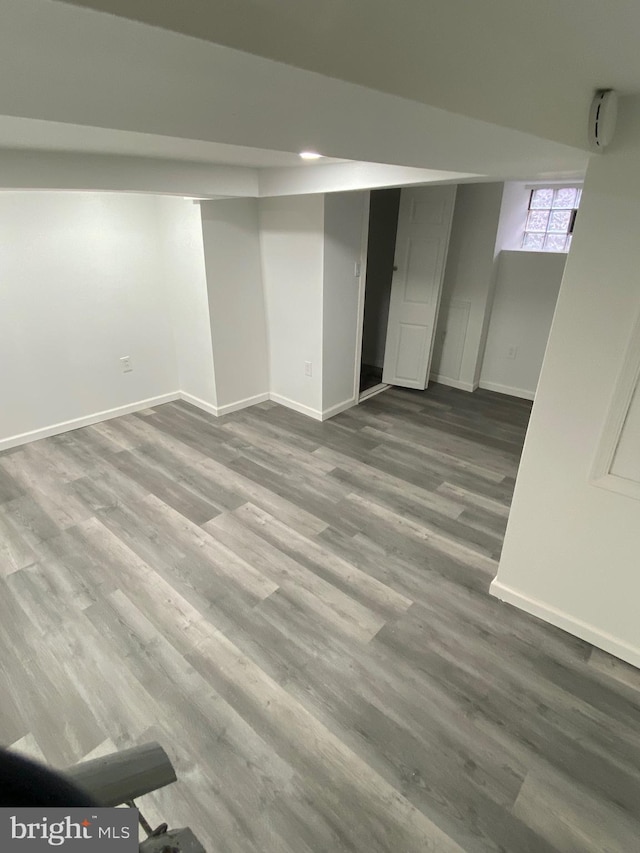 below grade area featuring baseboards and wood finished floors