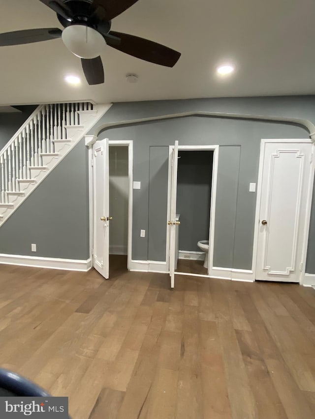 interior space with recessed lighting, ceiling fan, wood finished floors, baseboards, and stairs