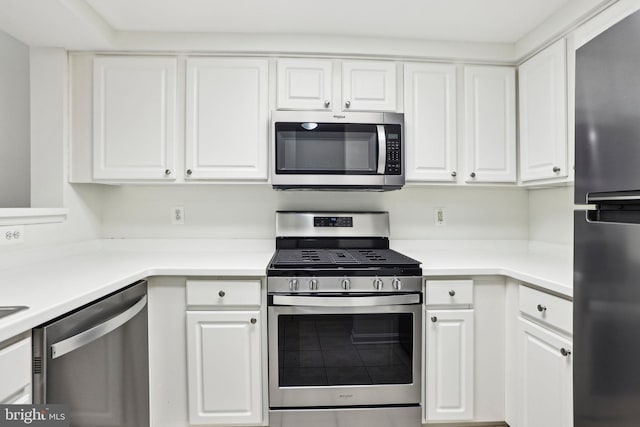 kitchen with appliances with stainless steel finishes, light countertops, and white cabinetry