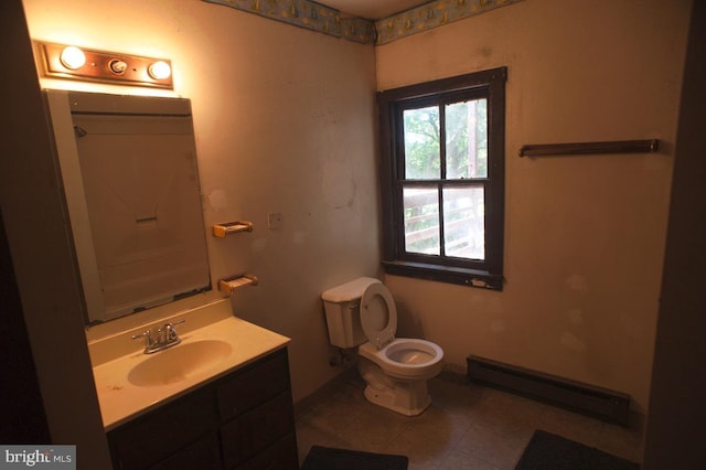 bathroom with a baseboard radiator, vanity, toilet, and tile patterned floors