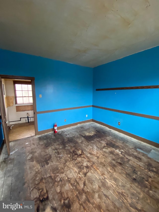 unfurnished room featuring wood finished floors and baseboards