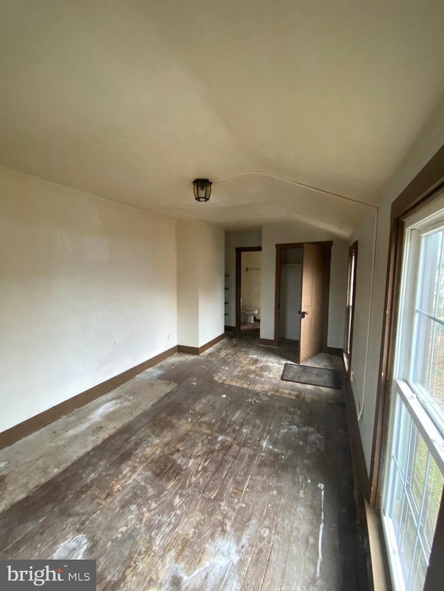 spare room featuring baseboards and wood finished floors