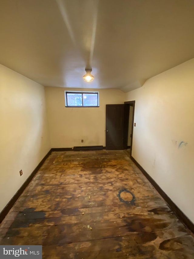 basement featuring a baseboard heating unit and baseboards