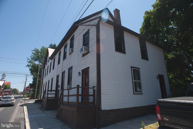 view of property exterior with cooling unit and a chimney