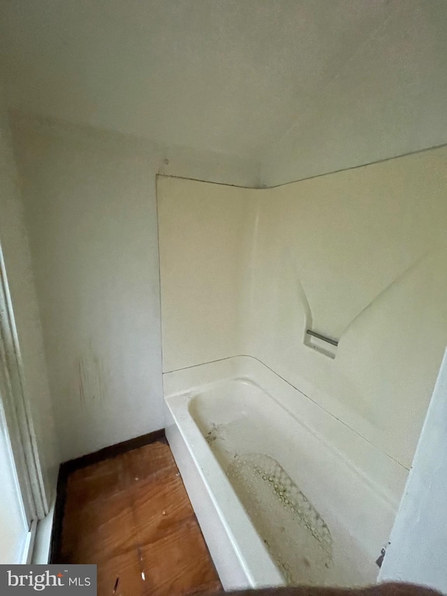 bathroom featuring wood finished floors and a washtub