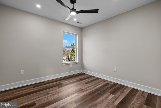 unfurnished room with a ceiling fan, visible vents, baseboards, and dark wood-type flooring