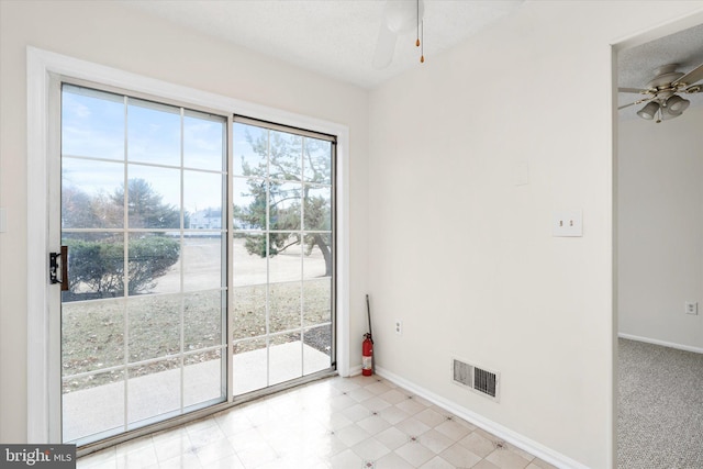 entryway with baseboards, a textured ceiling, visible vents, and a ceiling fan