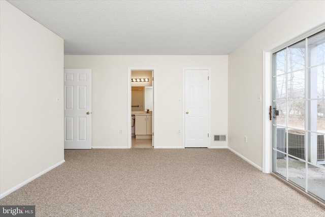 unfurnished bedroom featuring carpet floors, access to exterior, baseboards, and visible vents