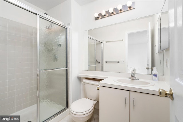 bathroom featuring vanity, a shower stall, and toilet