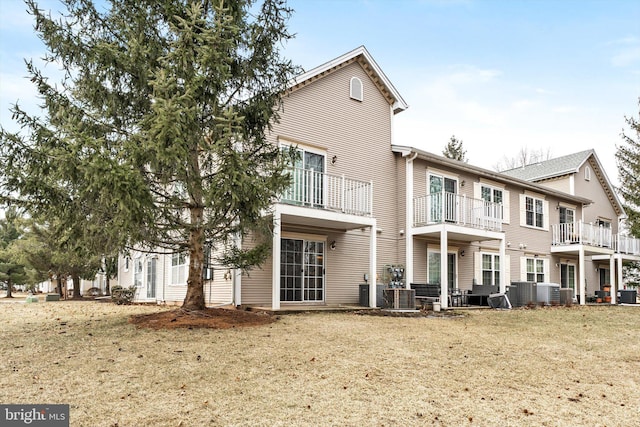 back of property featuring central AC unit and a yard