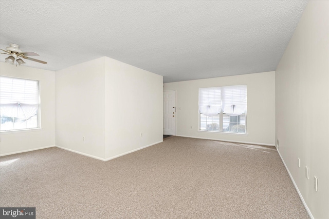 spare room with ceiling fan, a textured ceiling, baseboards, and carpet flooring