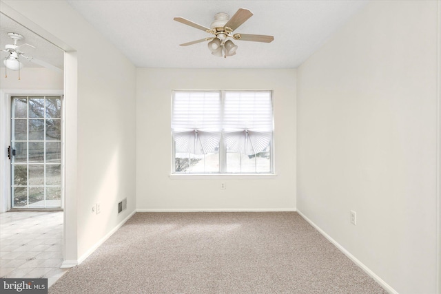 spare room with carpet floors, visible vents, ceiling fan, and baseboards