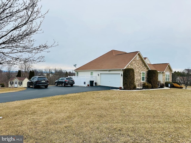 view of front of home featuring stone siding, driveway, and a front lawn