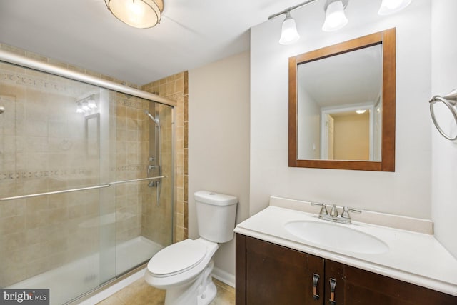 full bathroom featuring a stall shower, vanity, toilet, tile patterned flooring, and baseboards