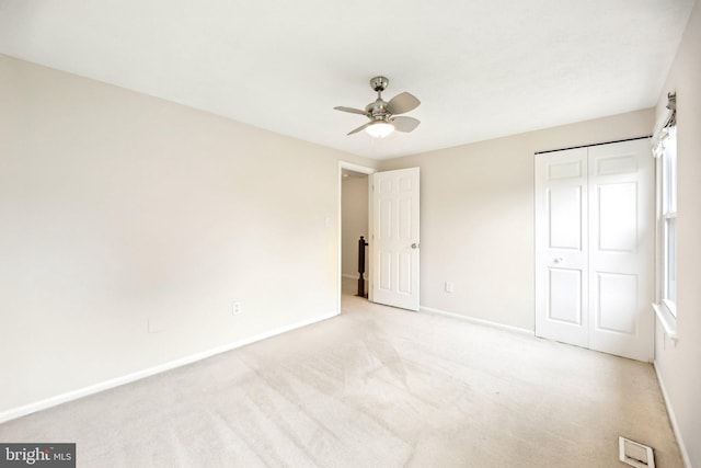 unfurnished bedroom featuring baseboards, carpet flooring, a closet, and ceiling fan