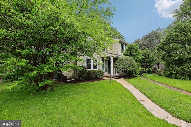 view of property hidden behind natural elements featuring a front yard