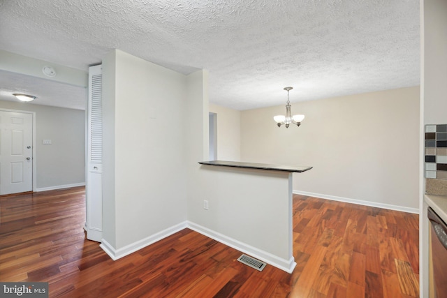 corridor featuring dark wood-style floors, a chandelier, baseboards, and a textured ceiling