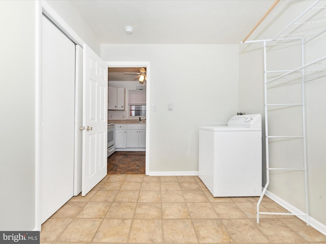 laundry room with ceiling fan, laundry area, a sink, baseboards, and washer / clothes dryer