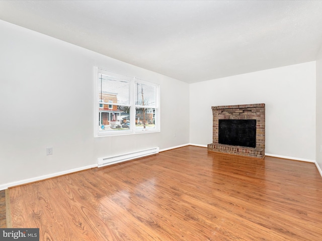 unfurnished living room featuring baseboards, a fireplace, a baseboard heating unit, and wood finished floors