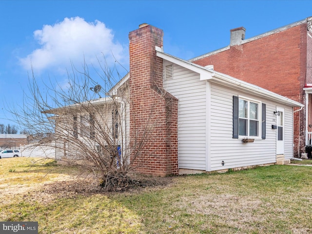 view of property exterior featuring a lawn and a chimney