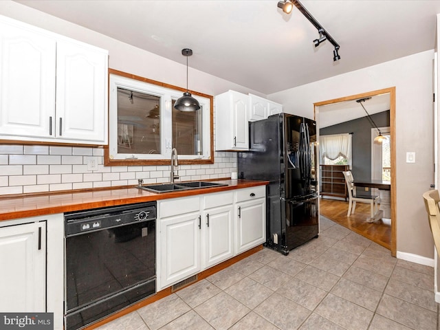 kitchen featuring white cabinets, black appliances, wood counters, and a sink