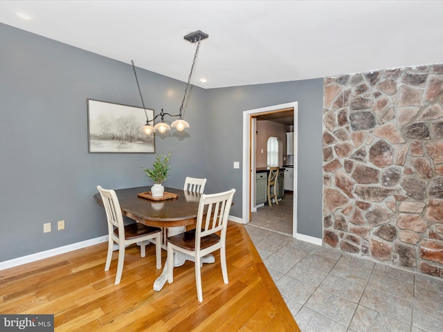 dining space with light wood-style flooring and baseboards