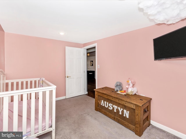 carpeted bedroom with baseboards and a nursery area