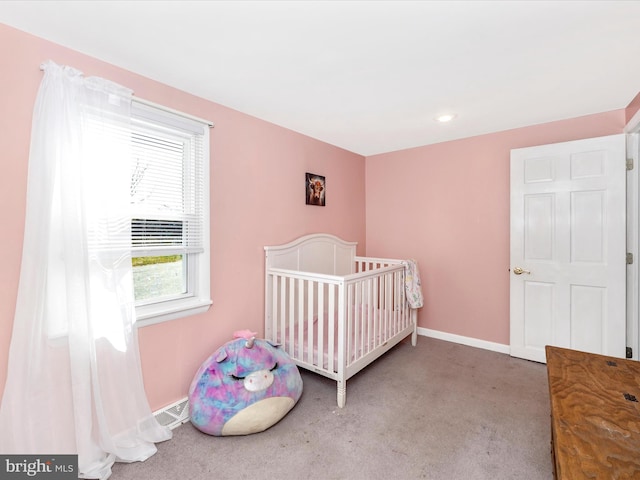 bedroom featuring carpet flooring, a nursery area, and baseboards