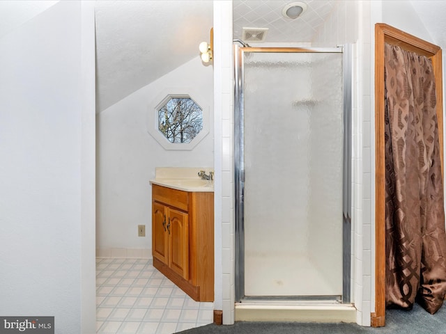 bathroom with vanity, a shower stall, visible vents, and vaulted ceiling