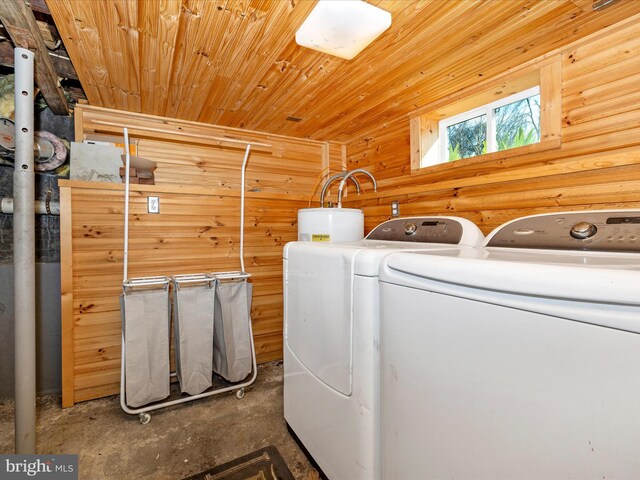 washroom with wooden ceiling, water heater, wood walls, and washing machine and clothes dryer