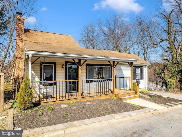 view of front facade featuring a porch and a chimney