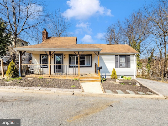 view of front of home featuring a porch and a chimney