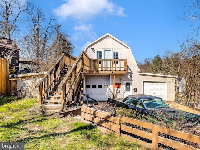 view of front of property with stairway, a gambrel roof, and a garage