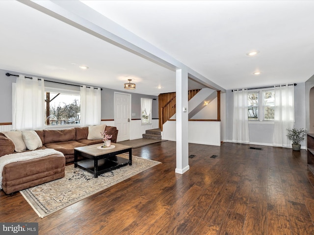 living room with baseboards, a healthy amount of sunlight, wood finished floors, and stairs