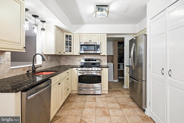 kitchen featuring cream cabinetry, stainless steel appliances, and a sink