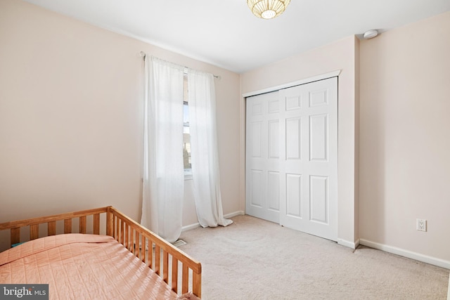 unfurnished bedroom with a closet, carpet flooring, and baseboards