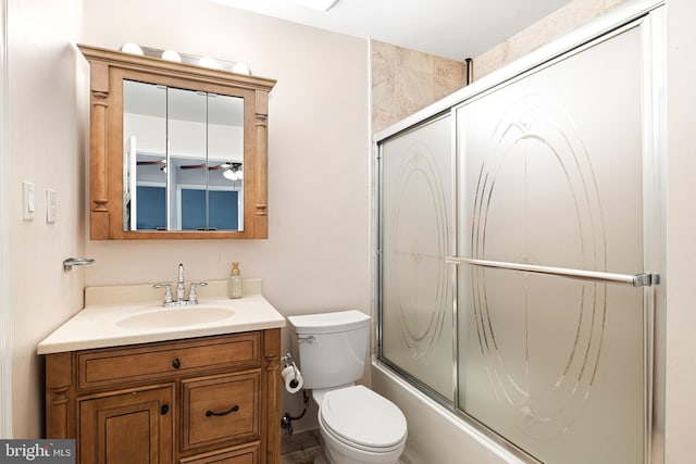 bathroom featuring vanity, toilet, and shower / bath combination with glass door