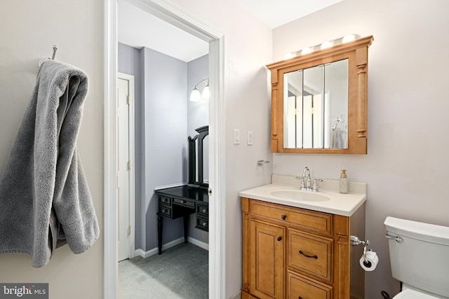 bathroom featuring baseboards, toilet, and vanity