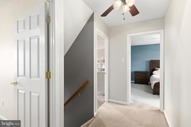 hallway with carpet flooring and baseboards