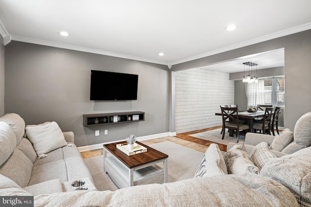 living room featuring ornamental molding, recessed lighting, baseboards, and a chandelier