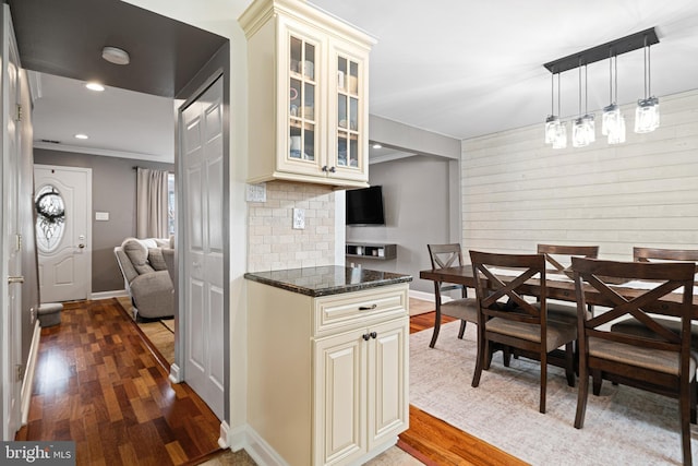 kitchen with cream cabinetry, tasteful backsplash, wood finished floors, recessed lighting, and glass insert cabinets