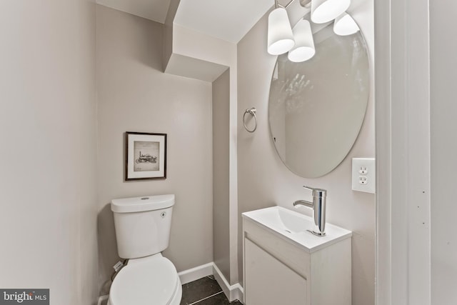 bathroom featuring baseboards, vanity, toilet, and tile patterned floors