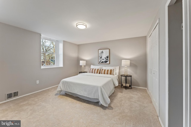 bedroom featuring baseboards, a closet, visible vents, and carpet flooring