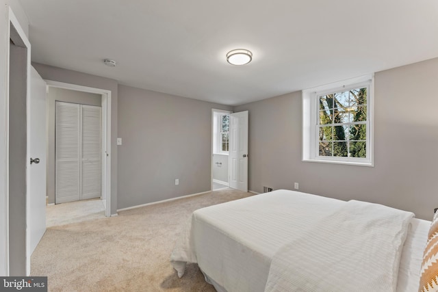 bedroom featuring light carpet and baseboards